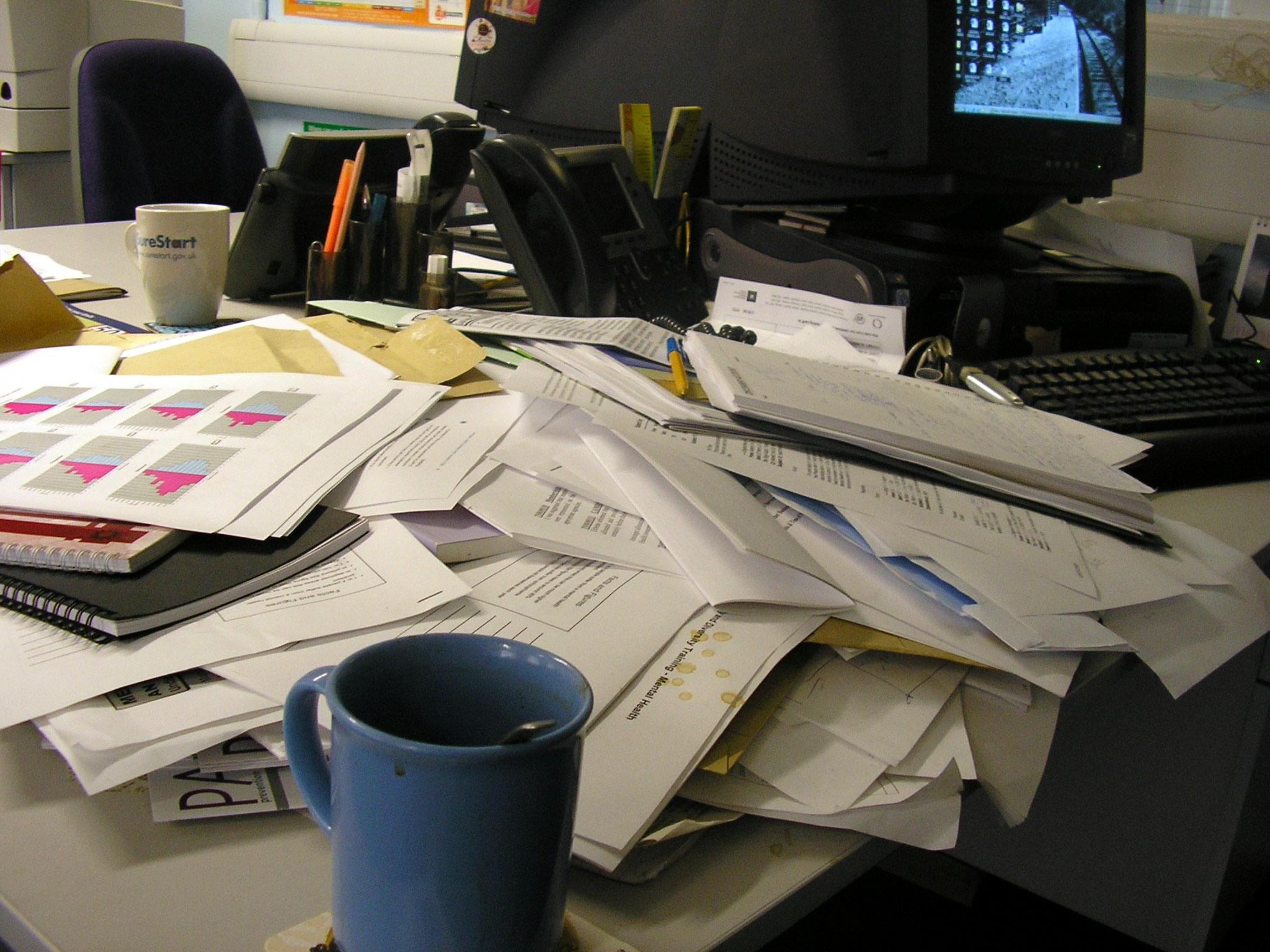 Много бумаг на столе. Бумаги на столе. Стол заваленный бумагами. Письменный стол заваленный бумагами. Письменный стол заваленный бумагами в офисе.